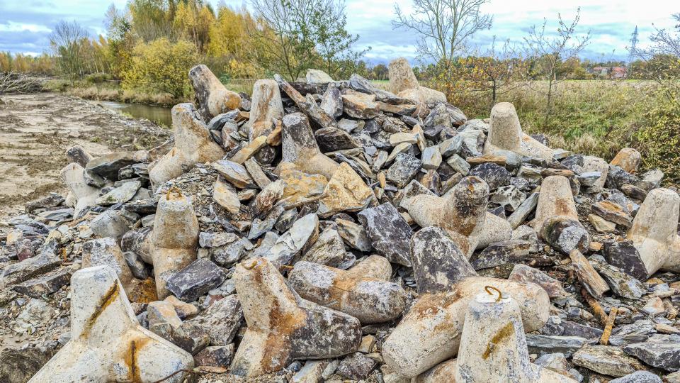 Berge von Steinen und Betonbauteilen zeigen, wie der Flussabschnitt bisher befestigt war. Eine naturnahe Entwicklung des Flussverlaufs war nicht möglich. 