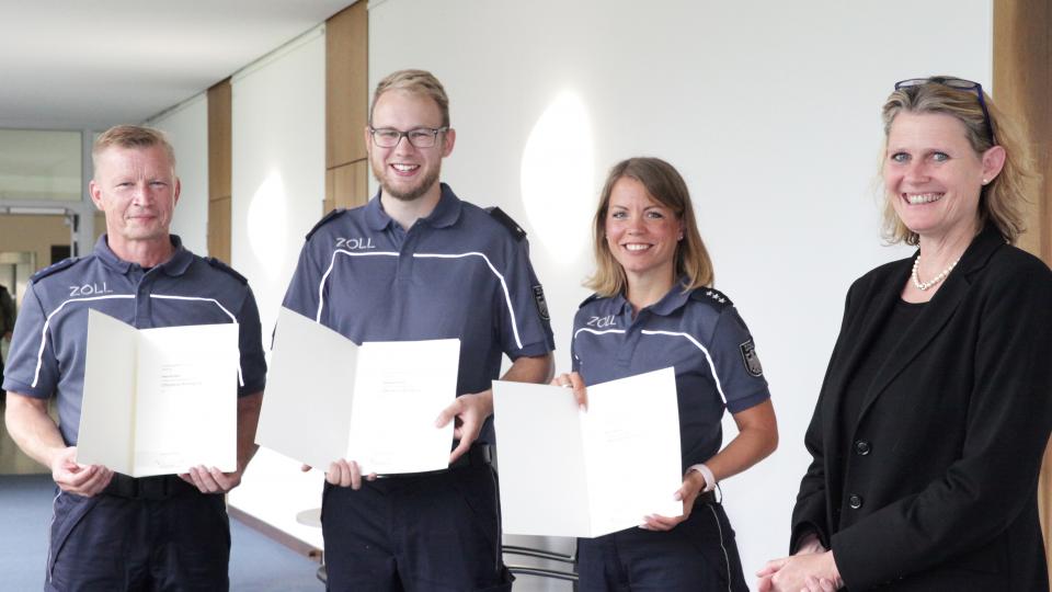 Regierungspräsidentin Judith Pirscher (rechts) hat Peter Schoppe aus Oerlinghausen (von links), Sebastian Fischer aus Leopoldshöhe und Sina Lehmann aus Bielefeld die Ehrenurkunde über die Belobigung des Landes Nordrhein-Westfalen übergeben.