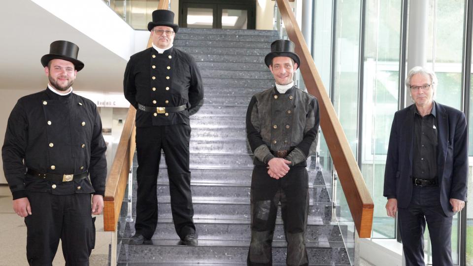 Der Vertreter des Gesellenausschusses, Konstantin Bauer (von links), Innungsobermeister Dirk Franck und Dezernatsleiter Josef Wegener (rechts) gratulieren Steffen Oenning zur Übernahme des Kehrbezirkes Herzebrock.