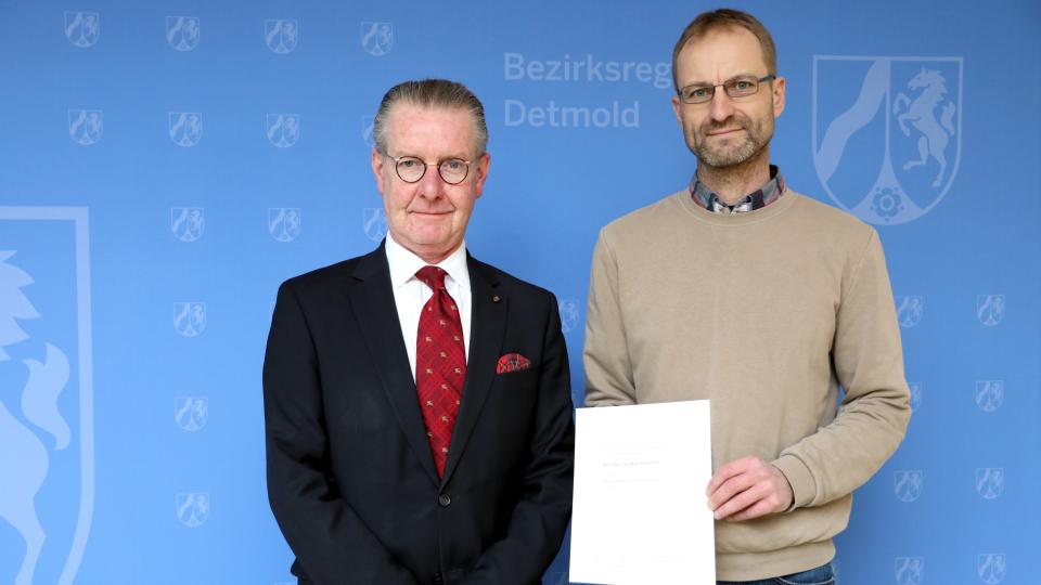 Frank Auf dem Hövel, Hauptdezernent für Kommunalaufsicht und Katasterwesen bei der Bezirksregierung Detmold (links), vereidigt Maik Aldejohann zum Öffentlich bestell-ten Vermessungsingenieur.