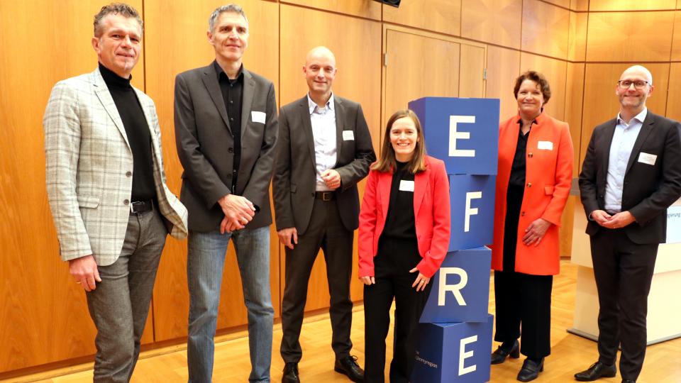 Das Bild zeigt die Personen, die bei der Infoveranstaltung zur Förderrunde REGIO.NRW auf dem Podium waren.
