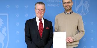 Frank Auf dem Hövel, Hauptdezernent für Kommunalaufsicht und Katasterwesen bei der Bezirksregierung Detmold (links), vereidigt Maik Aldejohann zum Öffentlich bestell-ten Vermessungsingenieur. 